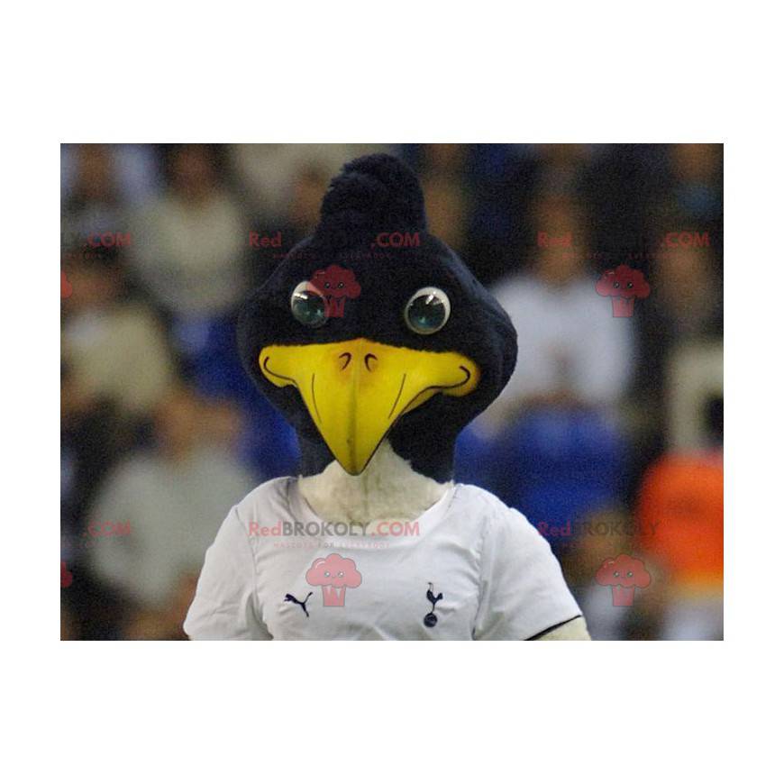 Mascotte d'oiseau noir et blanc en tenue de sport -