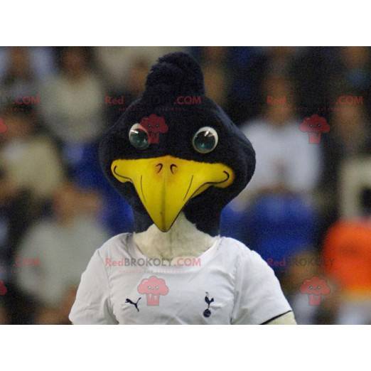 Mascotte d'oiseau noir et blanc en tenue de sport -