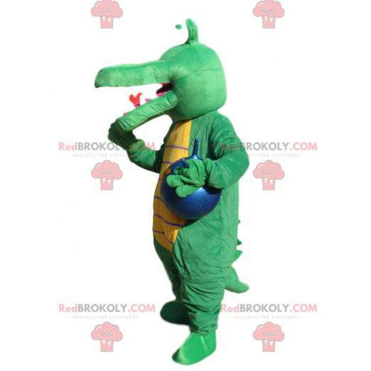 Mascota de cocodrilo verde con un globo azul. - Redbrokoly.com
