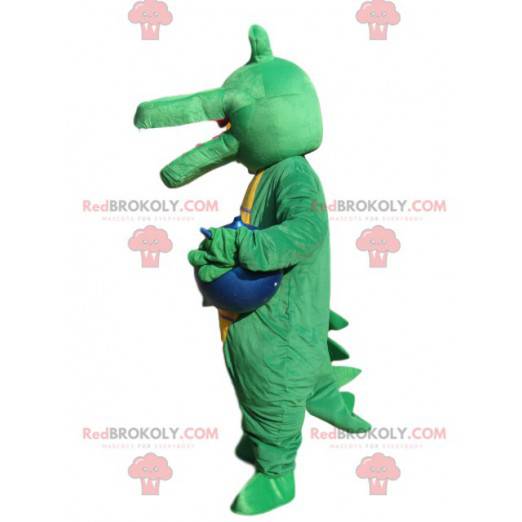 Mascotte coccodrillo verde con un palloncino blu. -