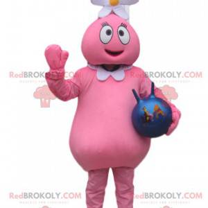 Mascota de personaje rosa con una flor en la cabeza y un globo.