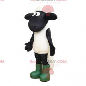 Biało-czarna maskotka owca z dużymi oczami i butami -