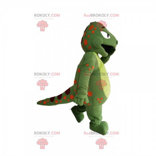 Grön dinosaurie-maskot med orange och vinröda prickar -