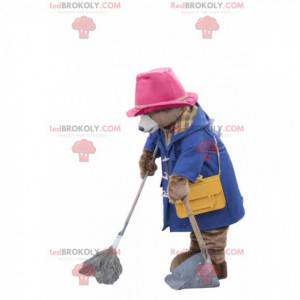 Orso mascotte con un cappotto blu e un cappello rosa -