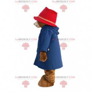Mascotte d'oursonne avec un manteau bleu et un chapeau rose -