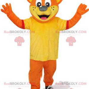 Orangenbärenmaskottchen mit gelbem T-Shirt und roter Mütze -