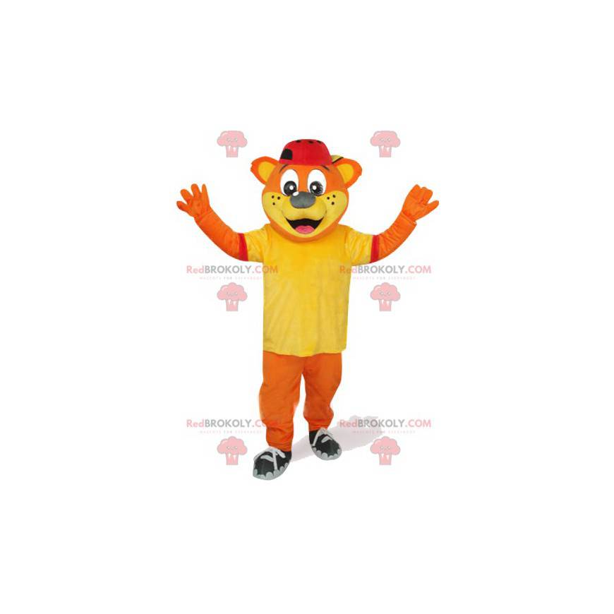 Oranžový medvěd maskot se žlutým tričkem a červenou čepicí -