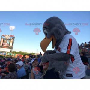 Mascota águila gris en ropa deportiva blanca y naranja -