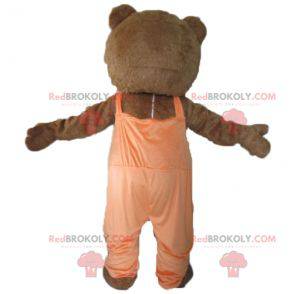 Mascotte d'ours marron et blanc avec une salopette orange -
