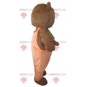 Mascotte d'ours marron et blanc avec une salopette orange -