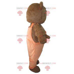 Mascotte d'ours marron et blanc avec une salopette orange -