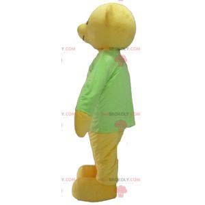 Gelbes Teddybärmaskottchen mit einem grünen T-Shirt -