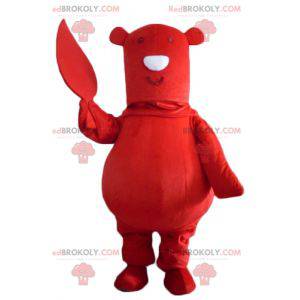 Mascote grande urso vermelho com uma folha na mão -