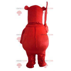 Mascote grande urso vermelho com uma folha na mão -