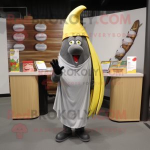 Gray Banana mascot costume character dressed with a T-Shirt and Shawl pins