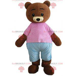 Piccolo marrone mascotte orso bruno con un vestito rosa e blu -