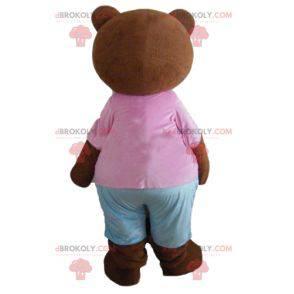 Piccolo marrone mascotte orso bruno con un vestito rosa e blu -