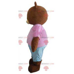Mascota oso pardo marrón con un traje rosa y azul -