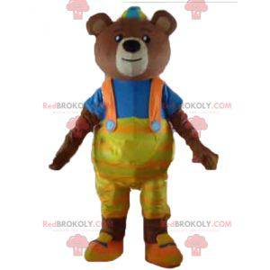 Braunbärenmaskottchen mit gelbem Overall und T-Shirt -