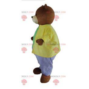 Mascotte d'ours marron habillé d'une tenue très colorée -