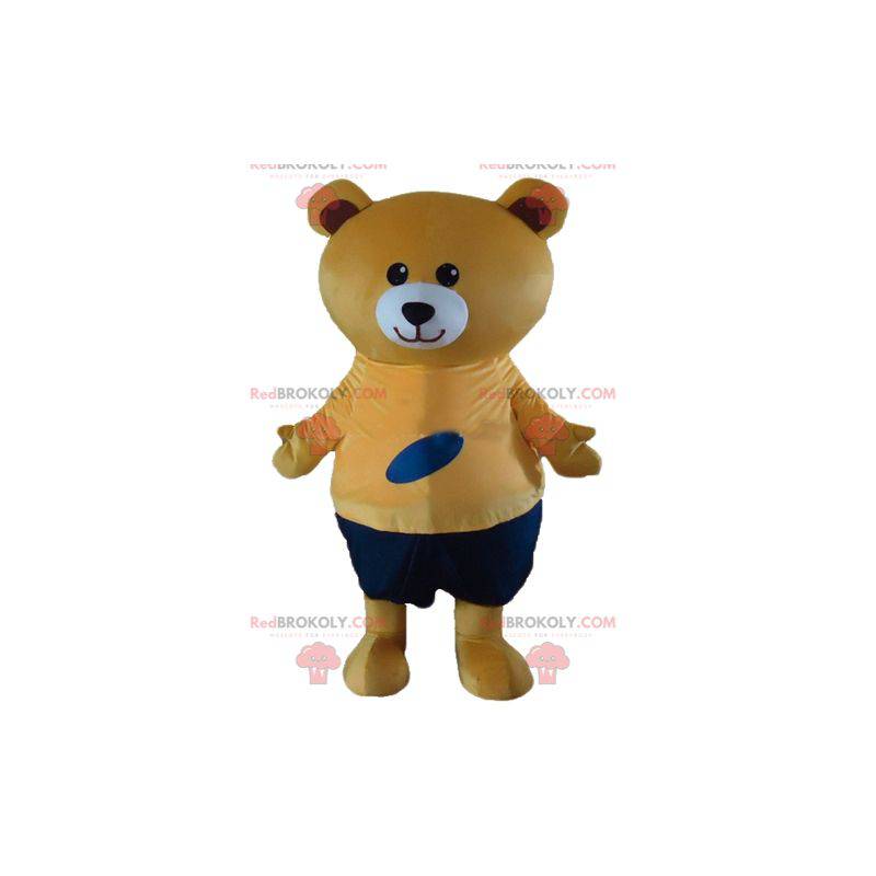 Big beige teddy bear mascot in orange and blue outfit -