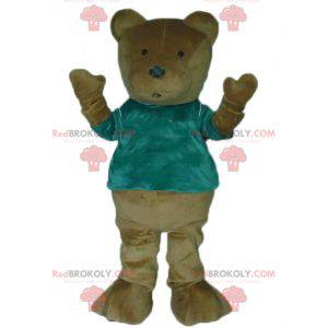 Braunes Teddybärmaskottchen mit einem grünen T-Shirt -