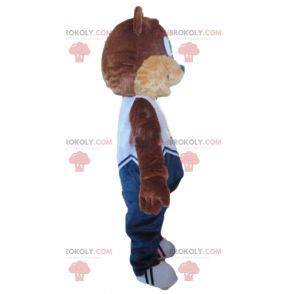 Mascote ursinho de pelúcia marrom e bege em traje azul -