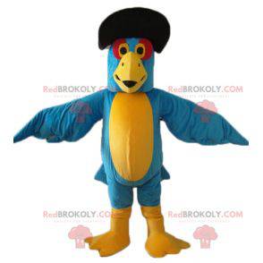 Blaues und gelbes Papageienmaskottchen mit einem schwarzen Hut