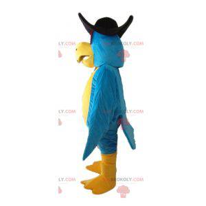 Mascote papagaio azul e amarelo com um chapéu preto -