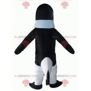Mascote pinguim preto e branco com um suéter azul -