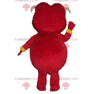 Mascotte de cochon rose habillé d'un costume rouge et jaune -