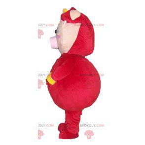 Pink gris maskot klædt i et rødt og gult kostume -