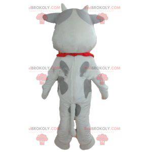 Mascota de vaca blanca y gris alegre y conmovedora -
