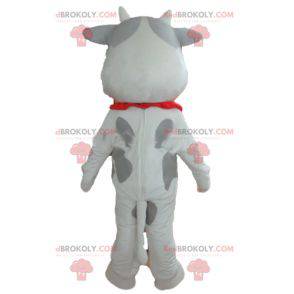 Mascota de vaca blanca y gris alegre y conmovedora -