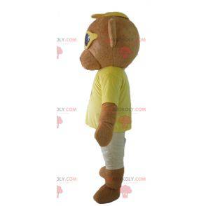 Brown teddy bear mascot in colorful outfit with glasses -