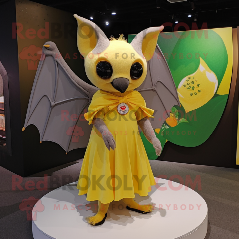 Yellow Fruit Bat mascot costume character dressed with a Pleated Skirt and Watches