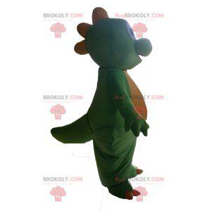 Linda y conmovedora mascota dinosaurio verde y amarillo. -