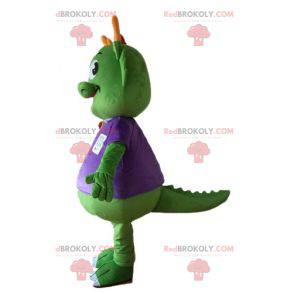 Green dinosaur mascot dressed in very warm purple -