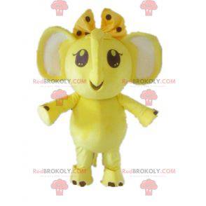 Mascote elefante amarelo e branco com um arco na cabeça -