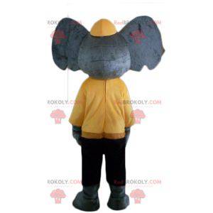 Graues Elefantenmaskottchen im gelben und schwarzen Outfit -