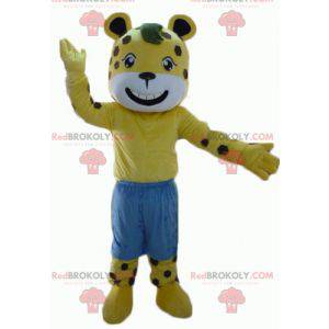 Mascotte de tigre jaune et blanc à pois marron avec un short -