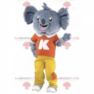 Szara maskotka koala w czerwono-żółtym stroju - Redbrokoly.com