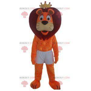 Mascotte leone arancione e rosso in pantaloncini con una corona