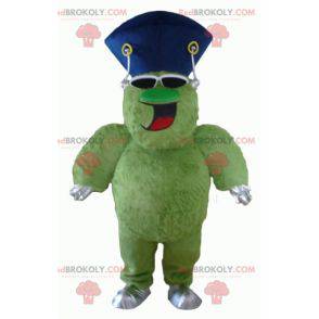 Mascote monstro verde peludo e gordo muito sorridente -