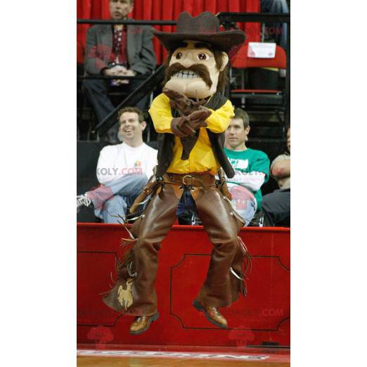 Mascote cowboy bigodudo em traje amarelo e marrom -