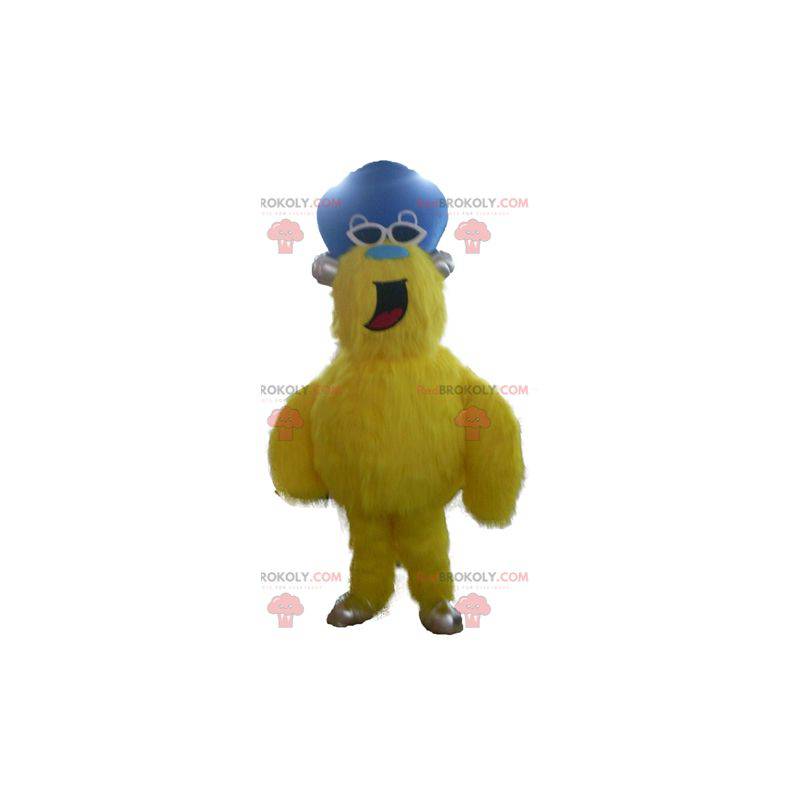 Mascotte de monstre jaune tout poilu avec un chapeau -