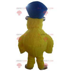 Mascote monstro amarelo e peludo com chapéu - Redbrokoly.com