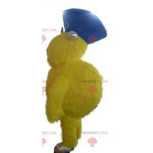 Mascotte de monstre jaune tout poilu avec un chapeau -