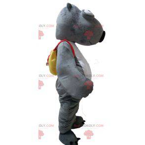 Mascota de castor animal gris y blanco con una mochila -