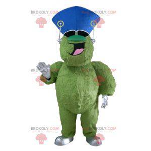 Mascote monstro verde peludo e gordo muito sorridente -